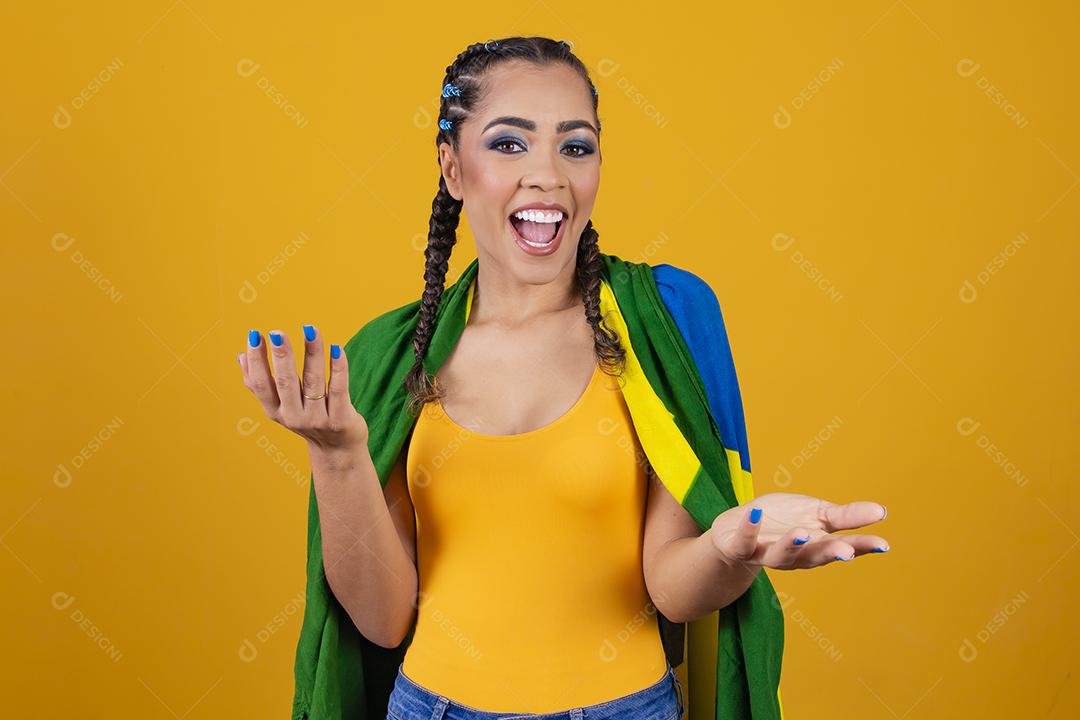 Torcedora brasileira. Fã brasileira comemorando partida de futebol em fundo cinza.