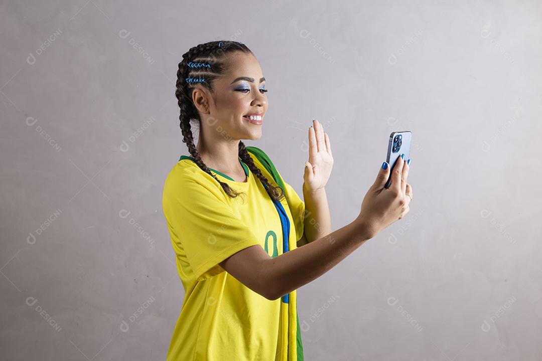 jovem apoiadora do brasil usando um celular para mensagem de texto
