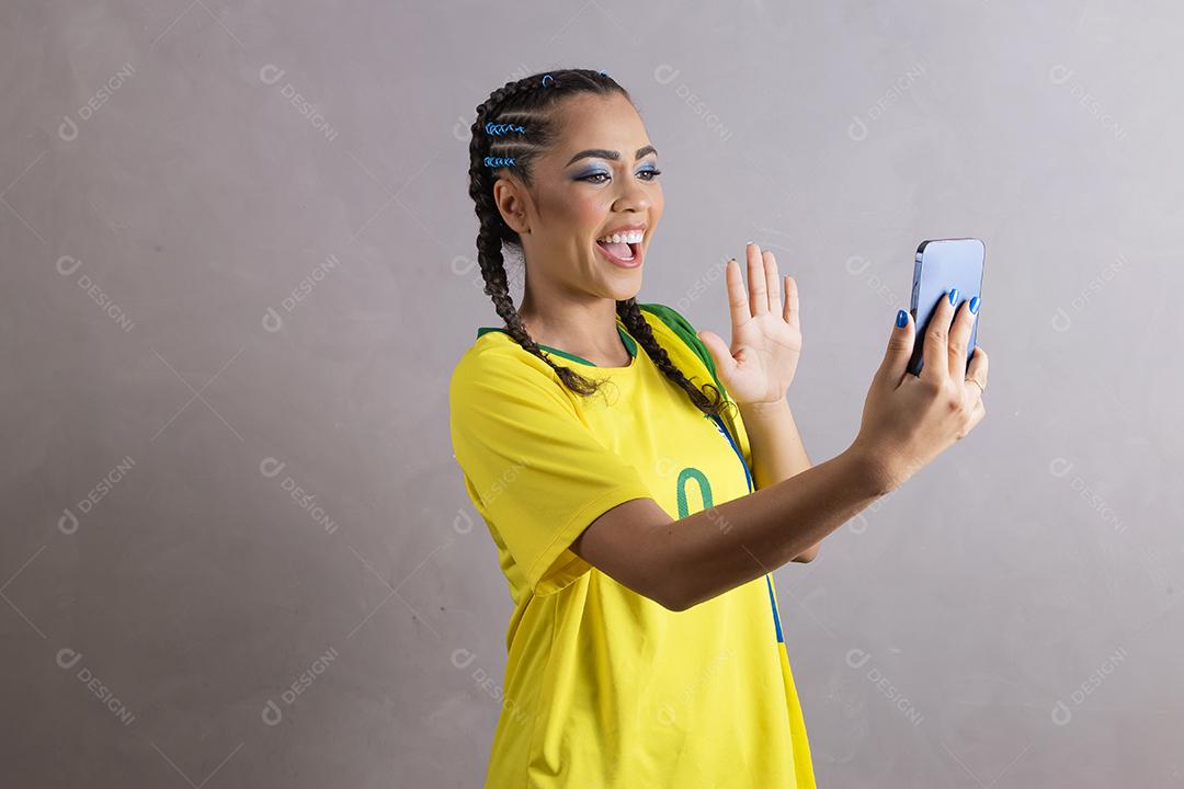 jovem apoiadora do brasil usando um celular para mensagem de texto