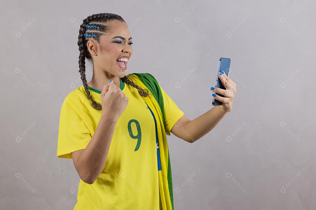 jovem apoiadora do brasil usando um celular para mensagem de texto