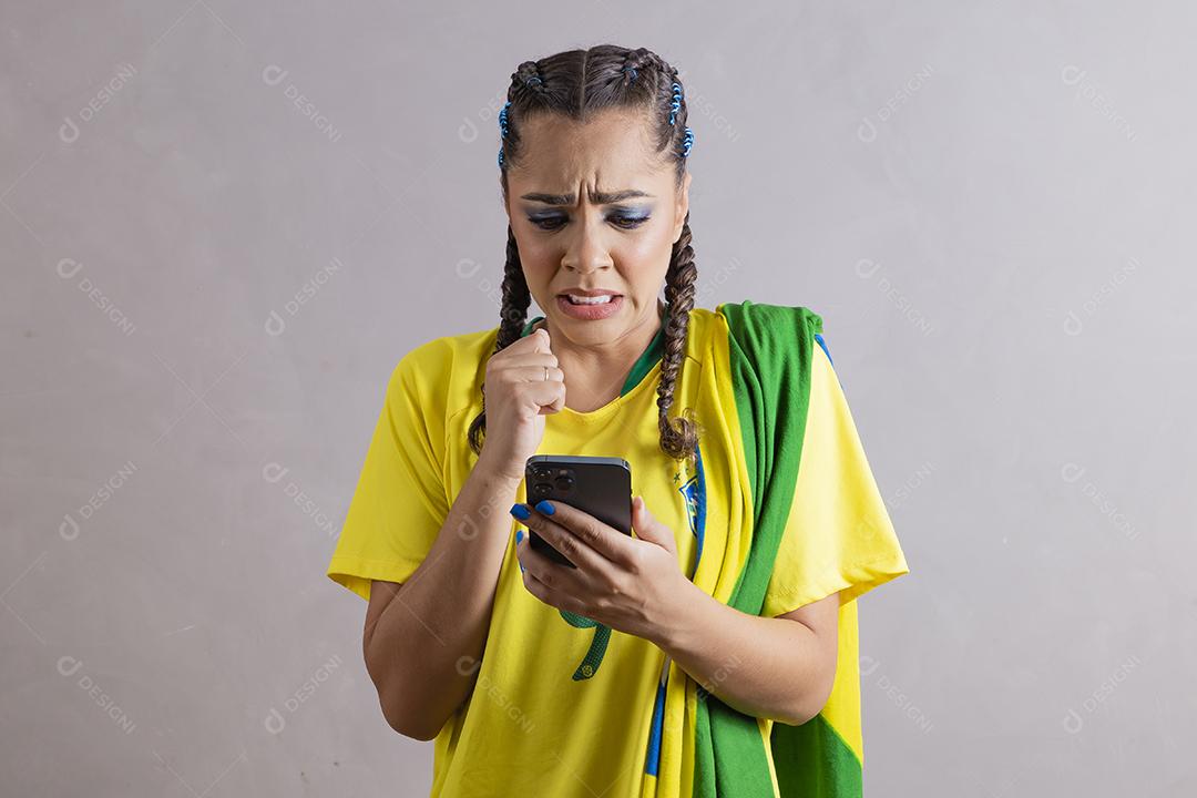 jovem apoiadora do brasil usando um celular para mensagem de texto