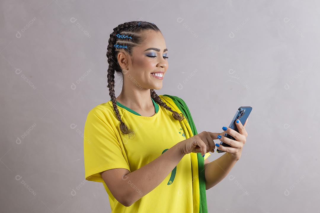 jovem apoiadora do brasil usando um celular para mensagem de texto