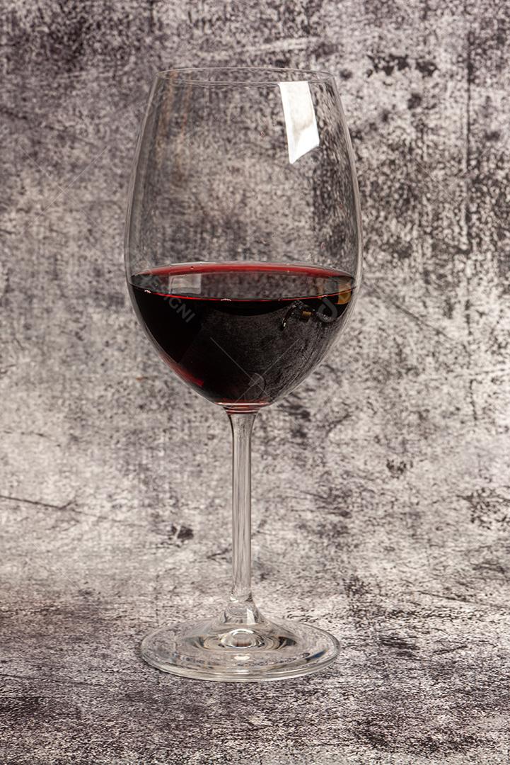 Copo de vinho tinto no fundo de mármore sem fim