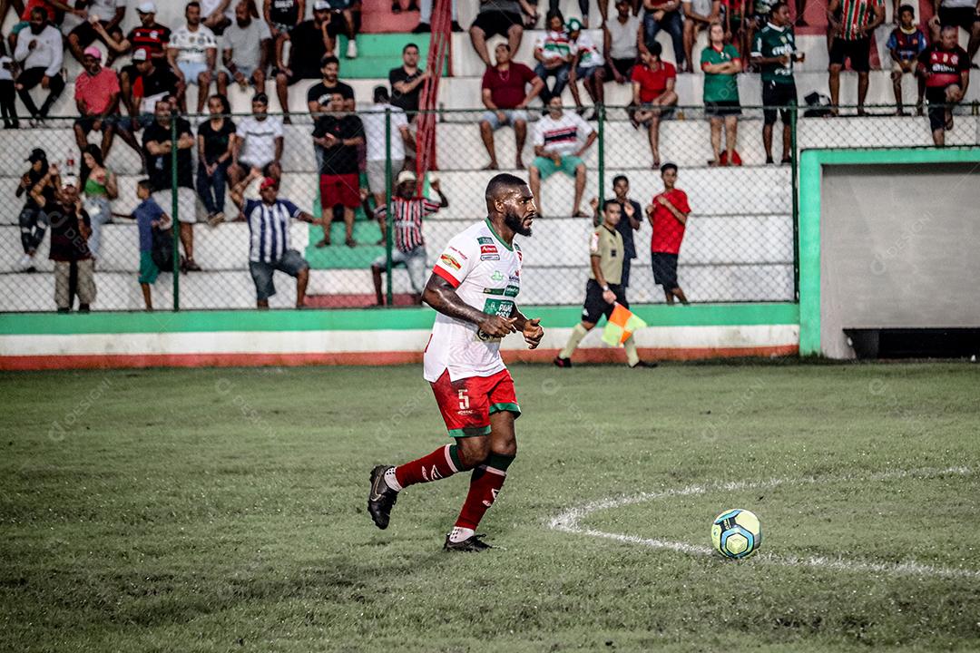 Homem jogador de futebol chutando bola