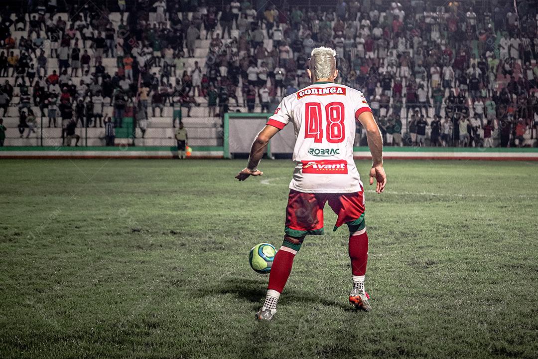 Homem jogador de futebol chutando bola