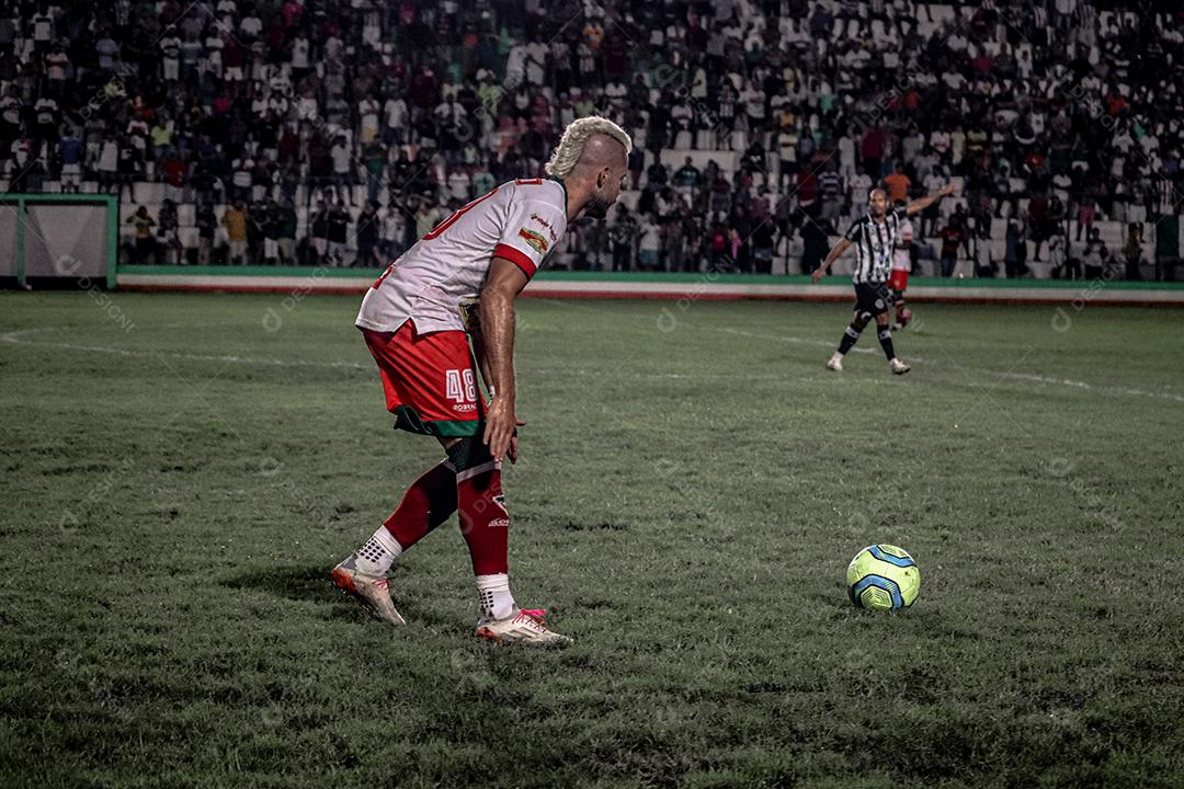 Homem jogador de futebol chutando bola