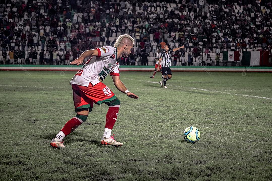 Homem jogador de futebol chutando bola