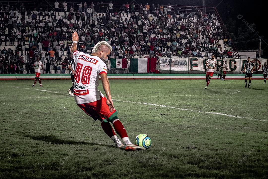 Homem jogador de futebol chutando bola