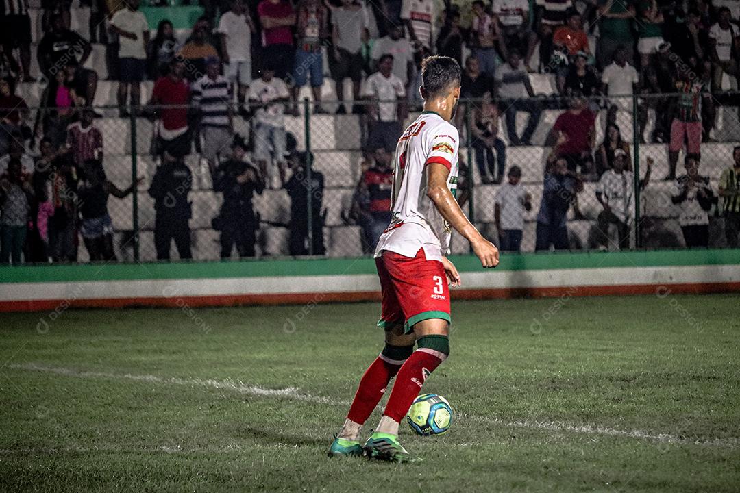 Homem jogador de futebol chutando bola