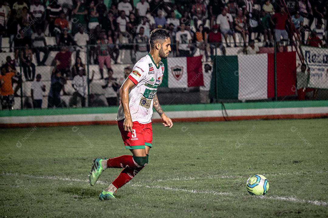 Homem jogador de futebol chutando bola