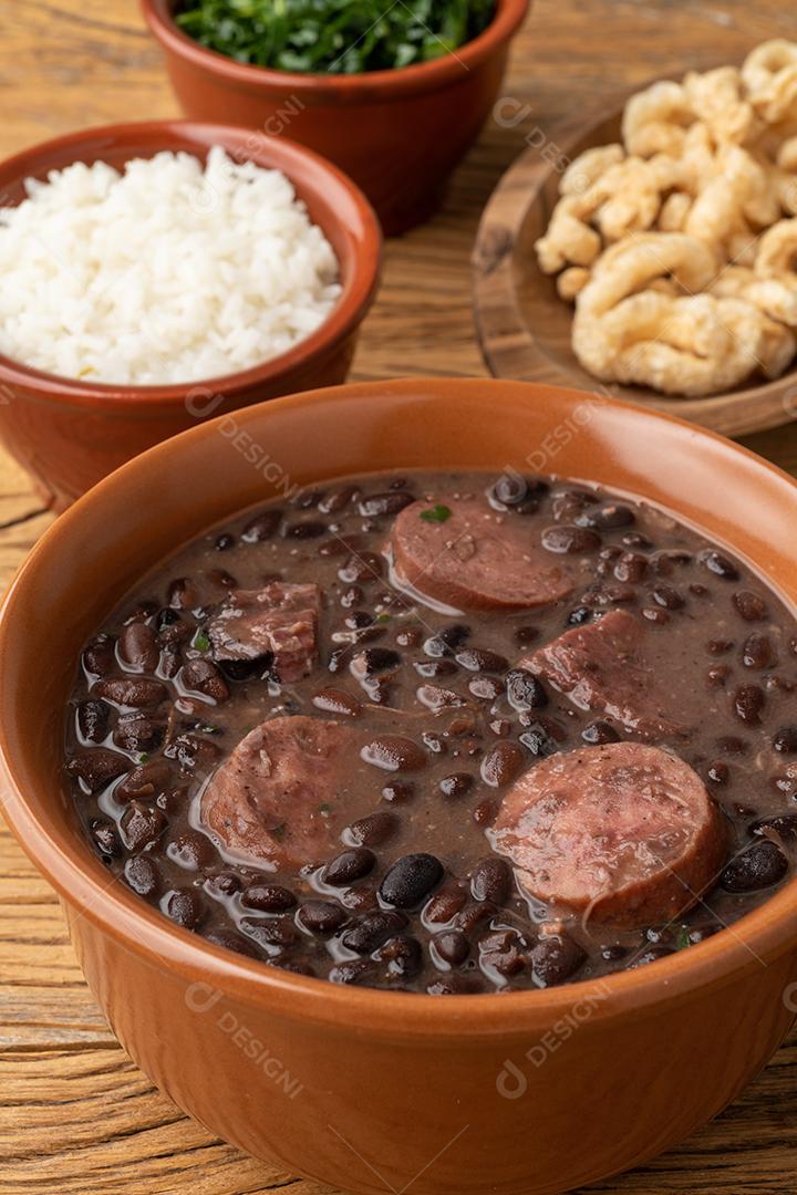 Típica feijoada brasileira com couve, arroz e torresmo