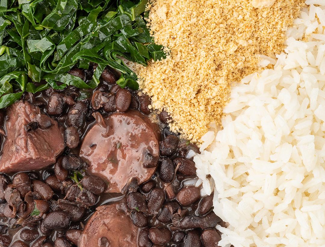 Típica feijoada brasileira com arroz, farofa, couve e torresmo