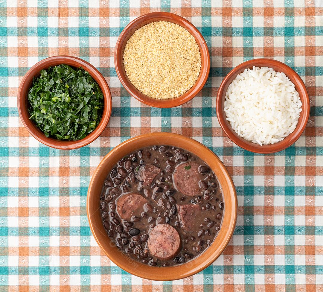 Feijoada típica brasileira com couve, arroz, torresmo