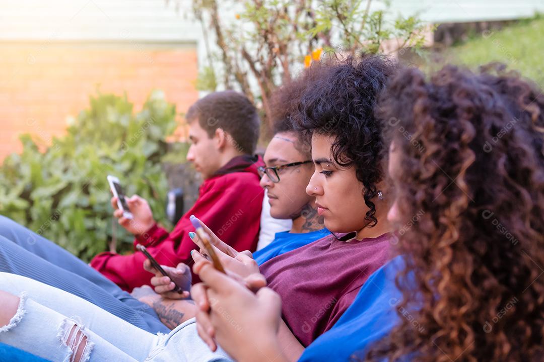 Grupo de amigos multirraciais usando smartphones para compartilhar conteúdo nas redes sociais