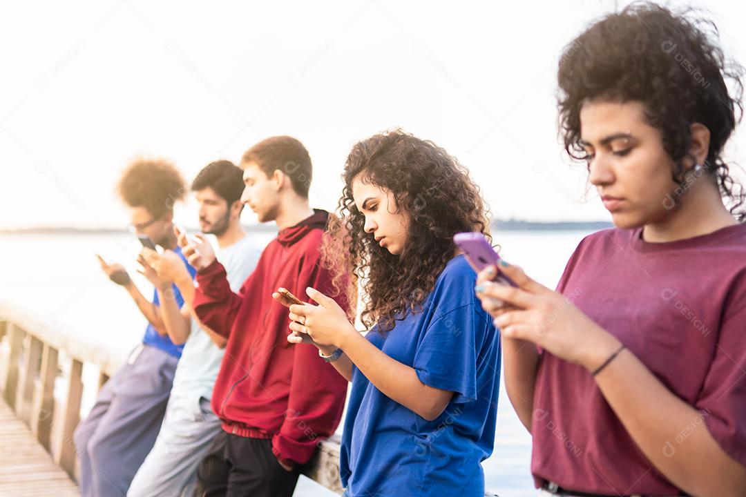 Grupo de amigos multirraciais usando smartphones para compartilhar conteúdo nas redes sociais