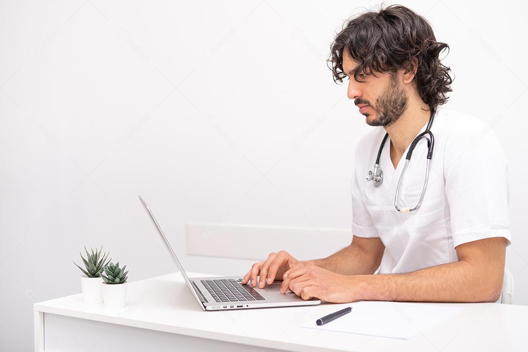 jovem médico com estetoscópio usando computador laptop falando videoconferência com paciente