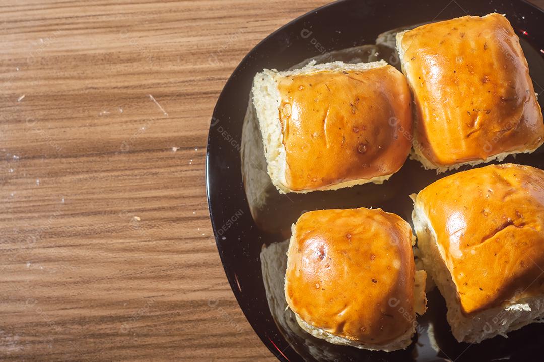 Pães e maçãs em um tablet de madeira e luz suave.