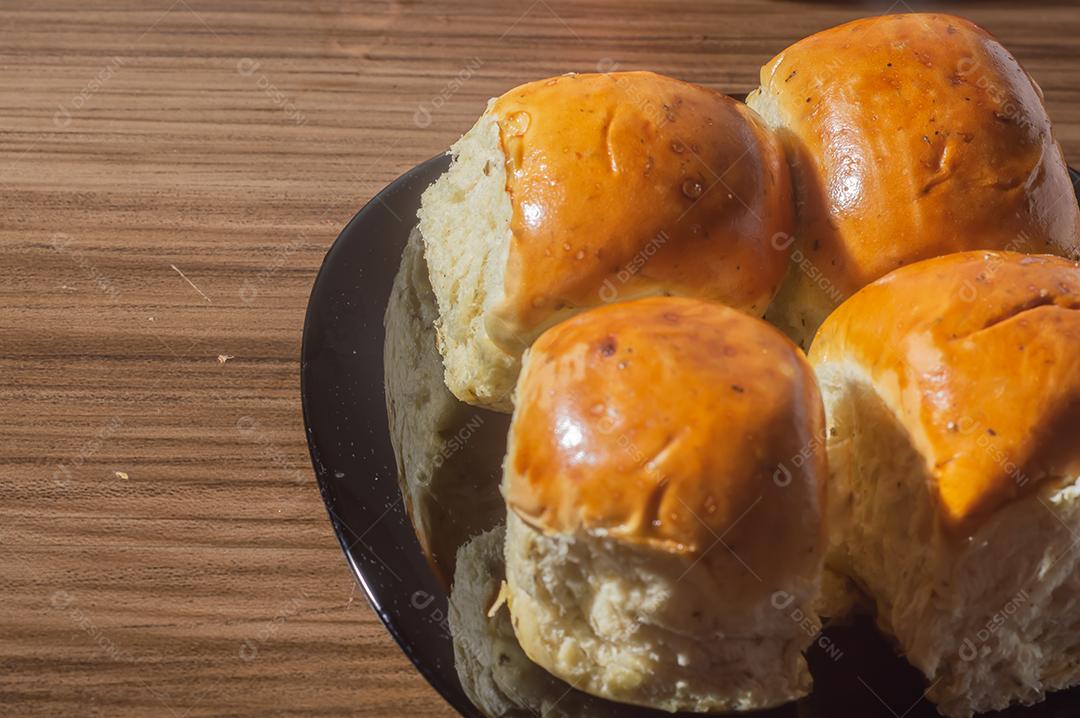 Pães e maçãs em um tablet de madeira e luz suave.