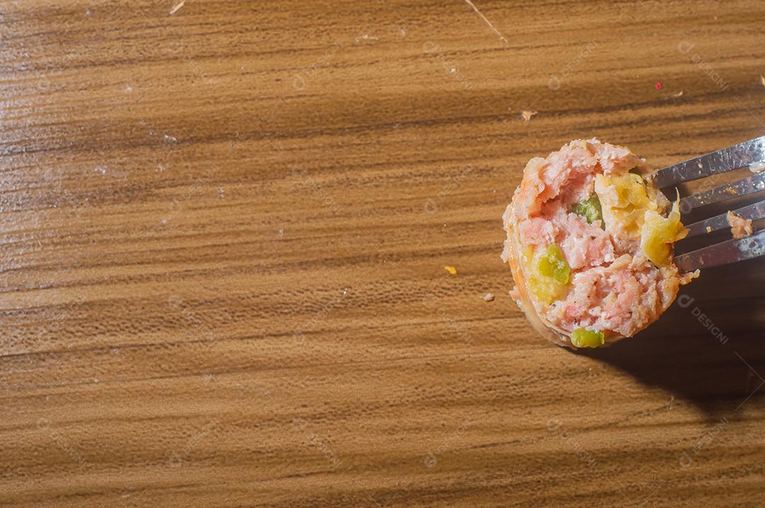 Salsicha feita com maçã e pimenta jaalapeno, em uma tábua de madeira com maçãs