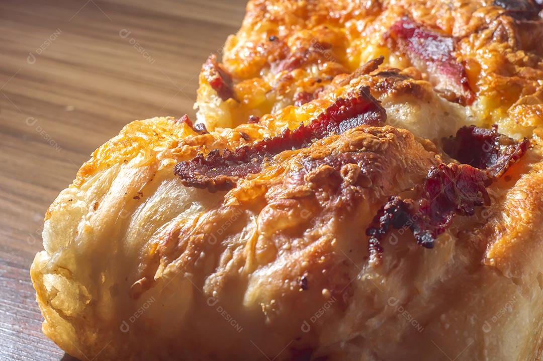 Foccacia italiana recém-assada com queijo amarelo e pastrami, em um tablet de madeira