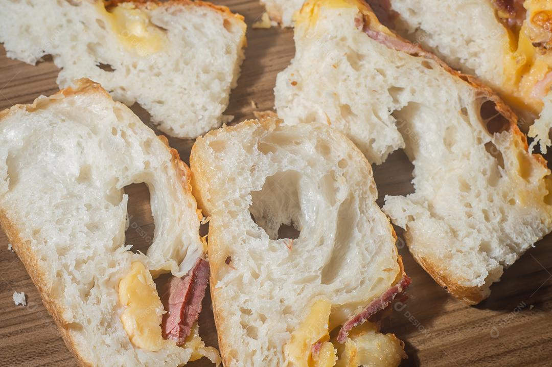 Foccacia italiana recém-assada com queijo amarelo e pastrami, em um tablet de madeira