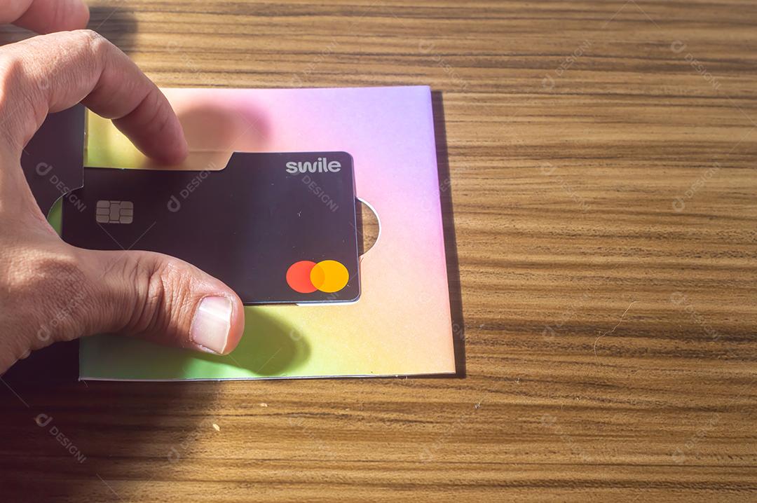 Campinas-sp,Brasil-10 de julho de 2022 : cartão swile com bandeira master card, em mesa de madeira