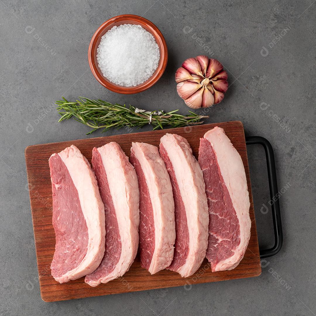 Picanha crua fatiada ou carne de alcatra sobre tábua de madeira com tempero