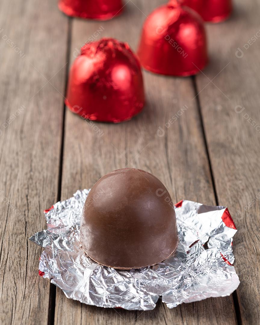 Doces de chocolate recheados com bombons embalados em papel alumínio vermelho