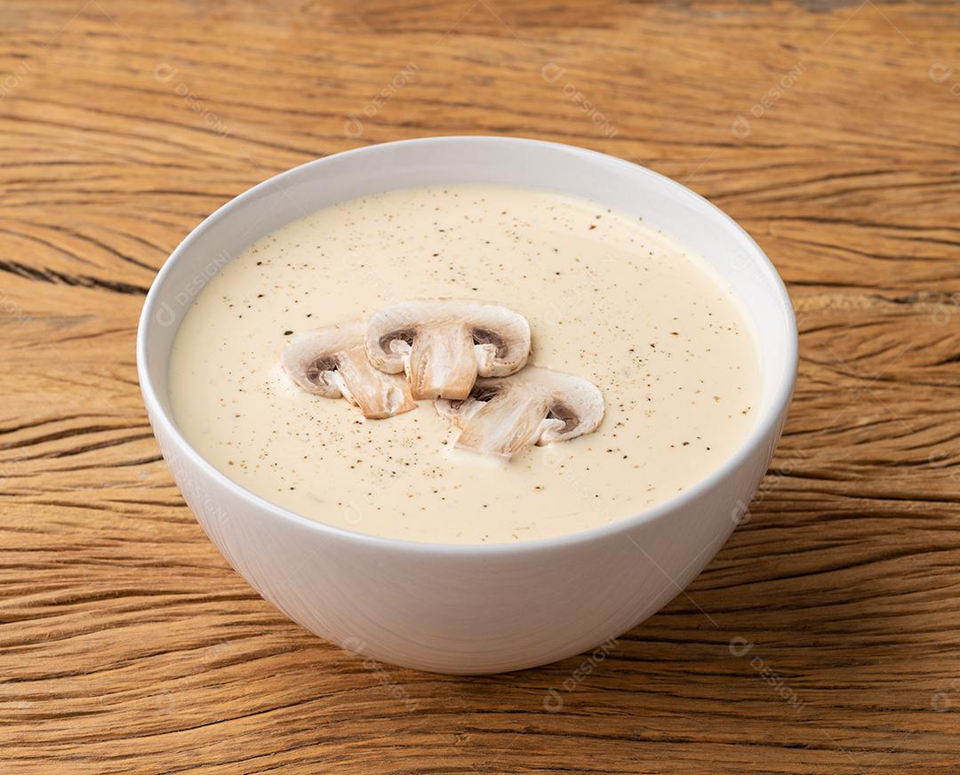 Sopa de cogumelos em uma tigela sobre a mesa de madeira