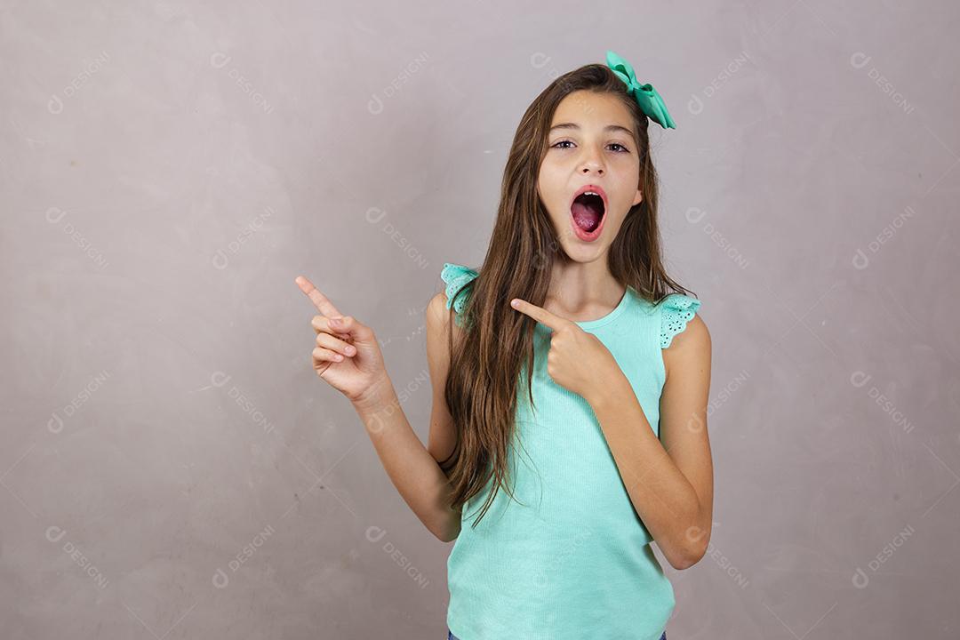 Adorável garota expressiva apontando para o lado