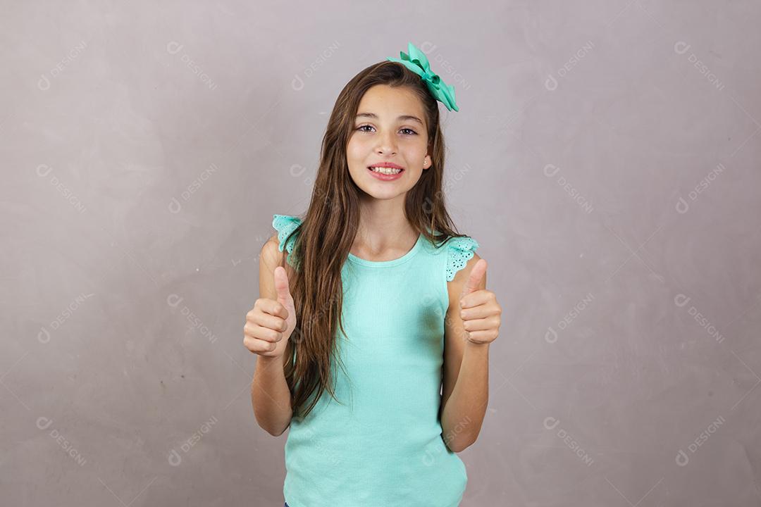 adorável garota caucasiana com o polegar para cima fazendo sinal okey, aprovado