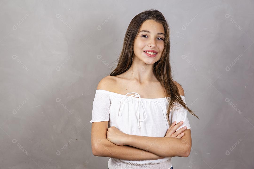 cara feliz de menina sorrindo com braços cruzados, olhando para a câmera. Pessoa positiva.