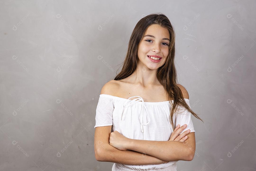cara feliz de menina sorrindo com braços cruzados, olhando para a câmera. Pessoa positiva.