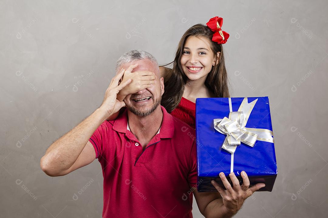 Dia dos Pais! Filha caucasiana cobrindo os olhos do pai segurando um presente de dia dos pais. Surpresa no dia dos pais