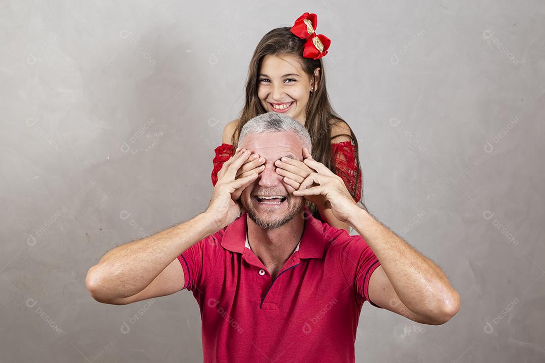 filha caucasiana, cobrindo os olhos do pai de surpresa.