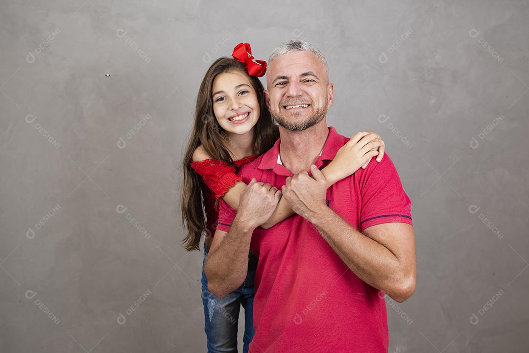 Feliz dia dos pais! Feliz pai caucasiano e filha abraçando no fundo liso