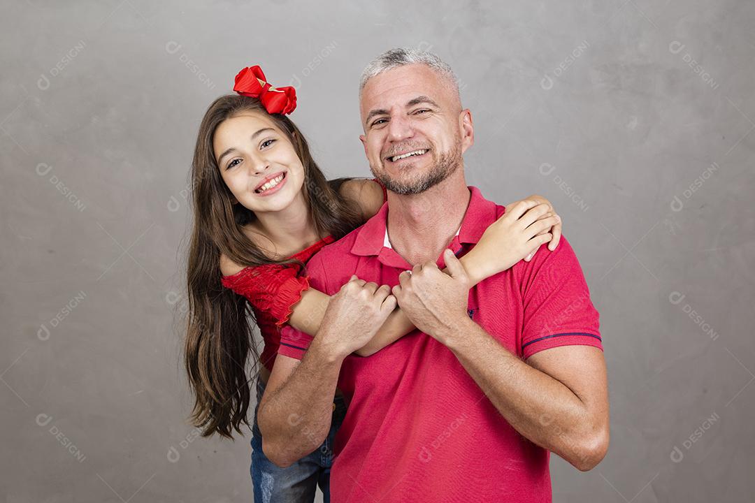 Feliz dia dos pais! Feliz pai caucasiano e filha abraçando no fundo liso