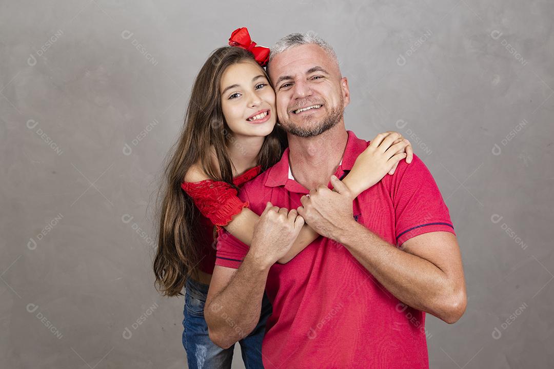 Feliz dia dos pais! Feliz pai caucasiano e filha abraçando no fundo liso