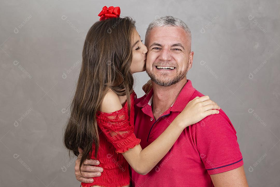 Menina beijando o pai na bochecha, pai feliz. Vista lateral