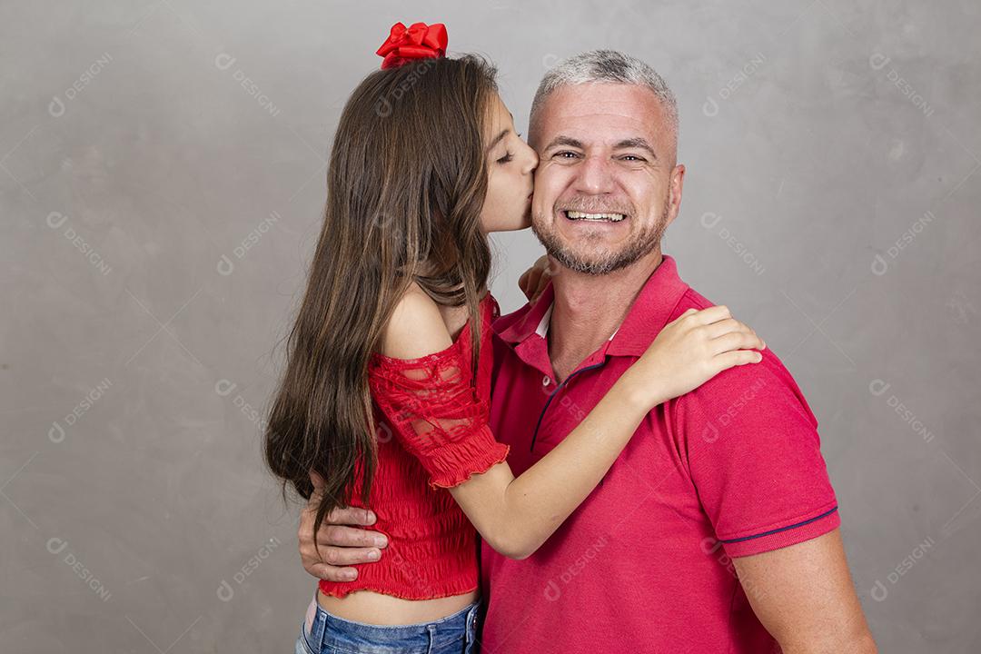 Menina beijando o pai na bochecha, pai feliz. Vista lateral