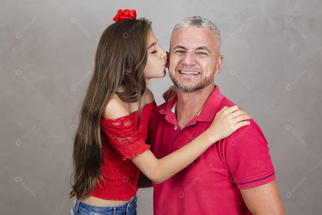 Menina beijando o pai na bochecha, pai feliz. Vista lateral