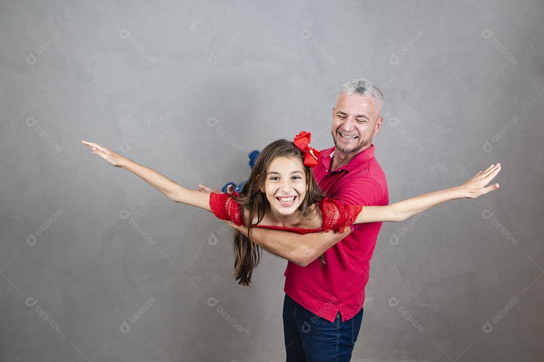 Dia dos Pais. Pai e filha adolescente jogando em fundo cinza.