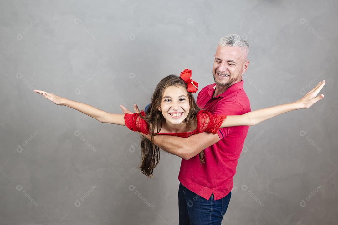 Dia dos Pais. Pai e filha adolescente jogando em fundo cinza.