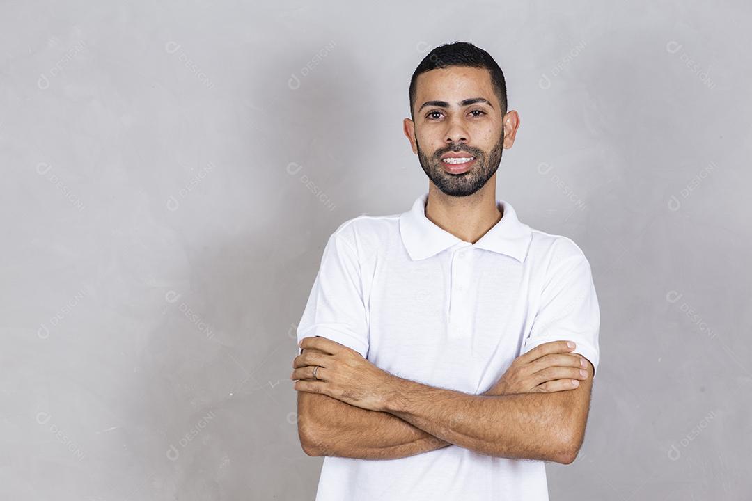 jovem menino afro feliz com os braços cruzados no fundo cinza