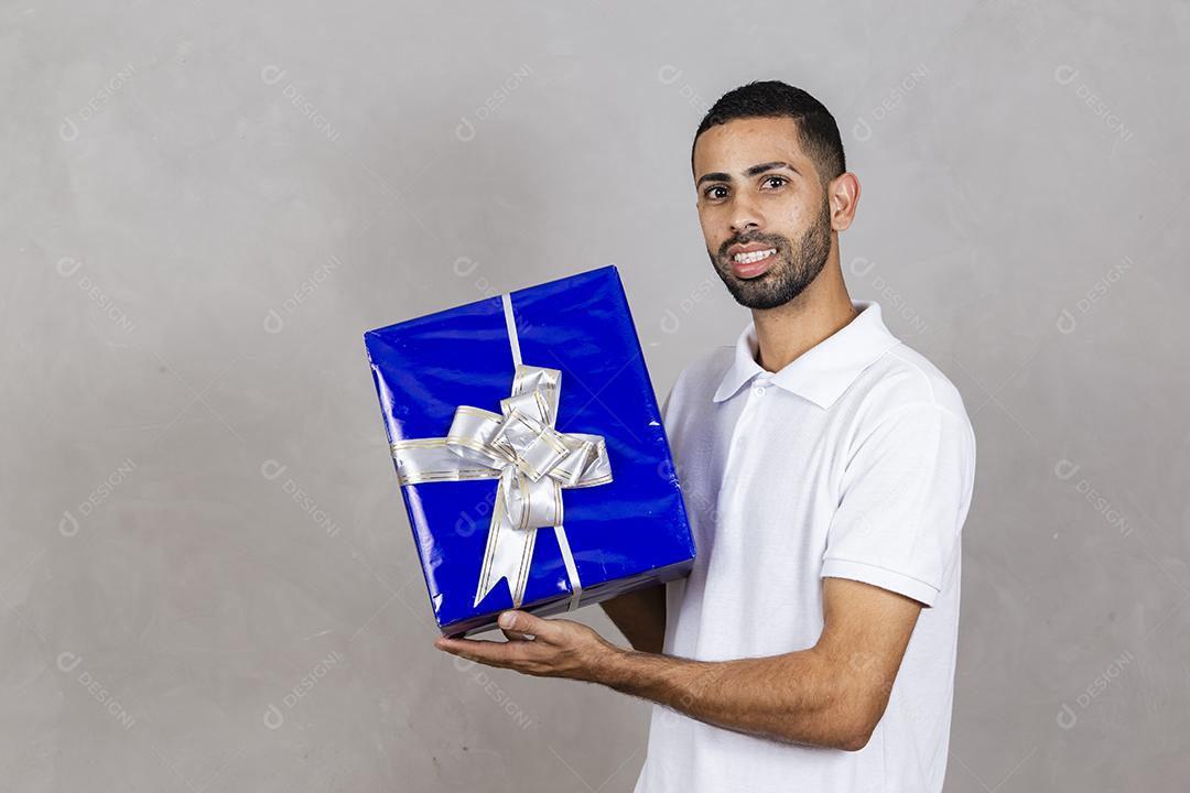 menino segurando uma caixa de presente em fundo cinza