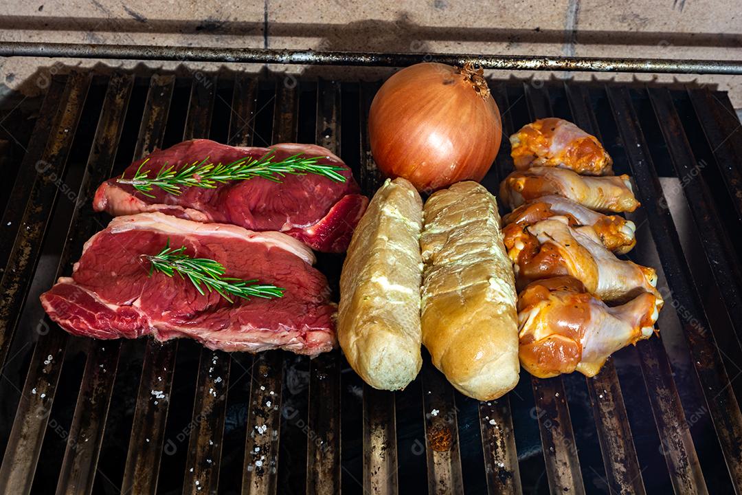 grelha com itens tradicionais do churrasco brasileiro, bife do lombo, pão de alho. coxinha de frango, cebola. tiro vertical