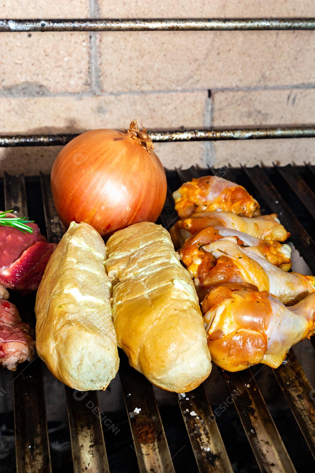 grelha com itens tradicionais do churrasco brasileiro, bife do lombo, pão de alho. coxinha de frango, cebola.