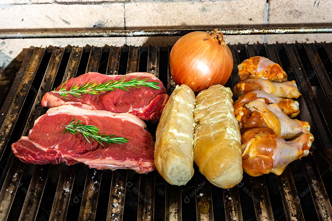 grelha com itens tradicionais do churrasco brasileiro, bife do lombo, pão de alho. coxinha de frango, cebola.