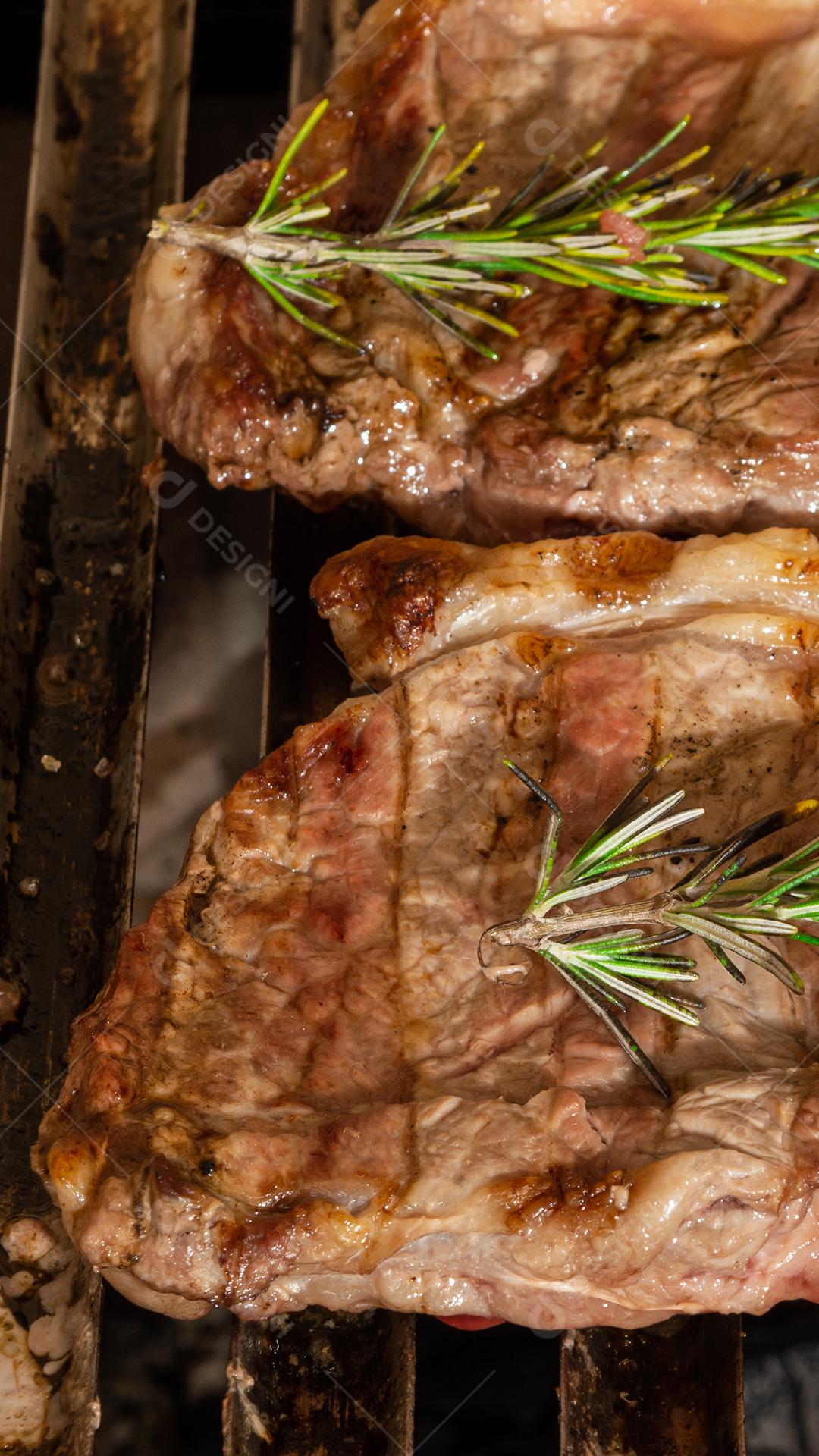 grelha com itens tradicionais do churrasco brasileiro, bife do lombo, pão de alho. coxinha de frango, cebola.