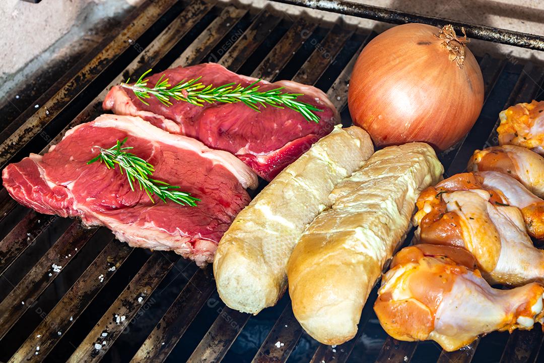 grelha com itens tradicionais do churrasco brasileiro, bife do lombo, pão de alho. coxinha de frango, cebola.